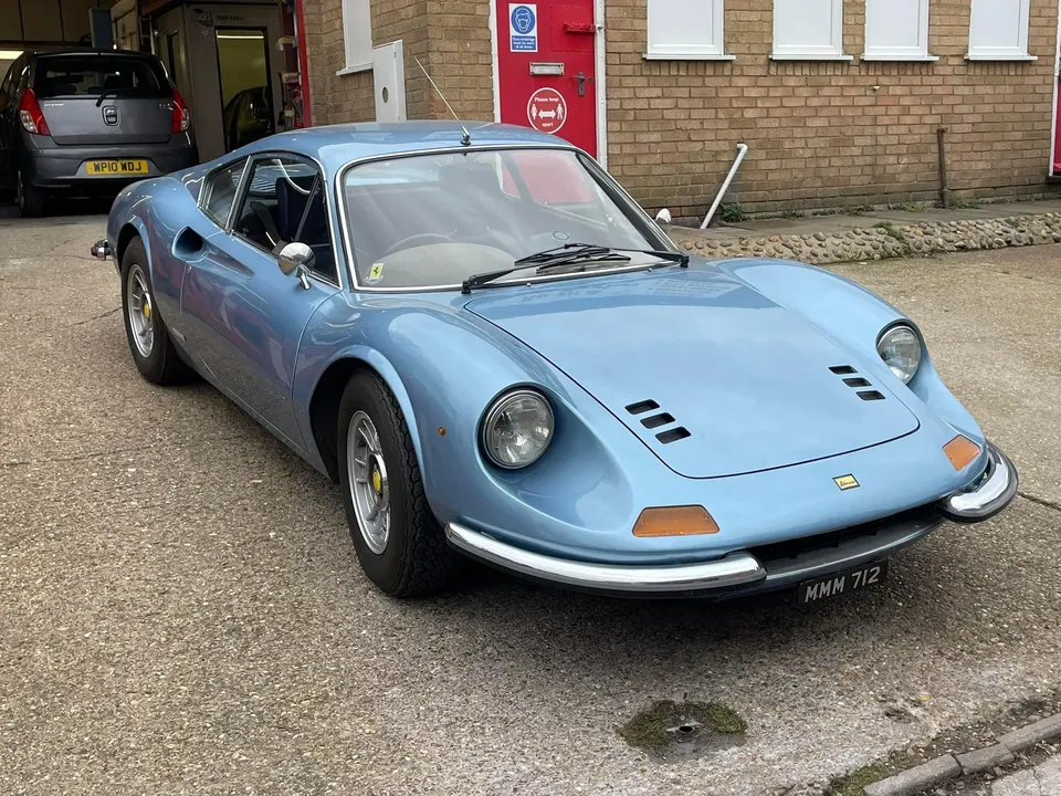 Light blue Ferrari Dino parked on the forecourt outside the workshop