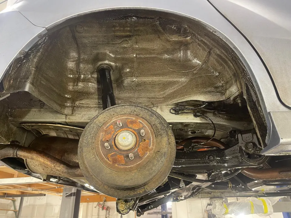 Rear wheel arch of the Honda with the liner off, showing surface rust
