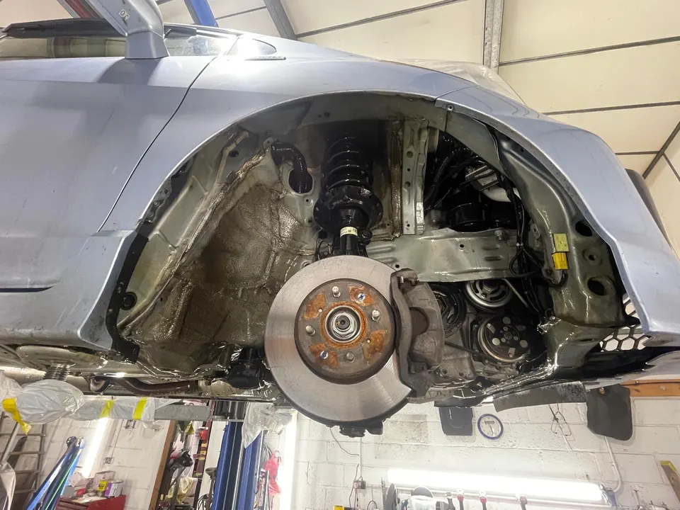 Front wheel arch and suspension strut with the liner removed