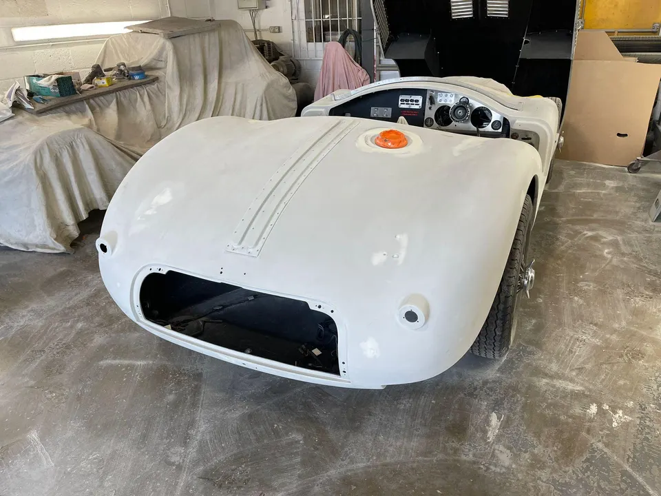 White open two-seater sports car body in primer in the workshop